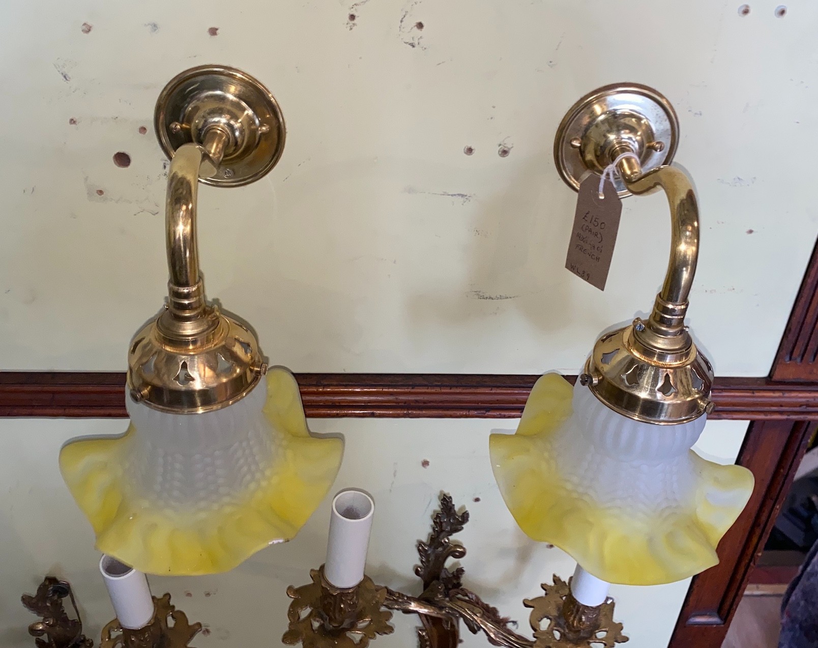 A pair of 1930s French lacquered brass wall lights with yellow tinted quilted and frosted glass shades, height 19cm